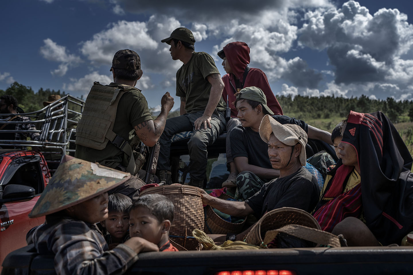 Ten people crowd in the back of a truck with possessions