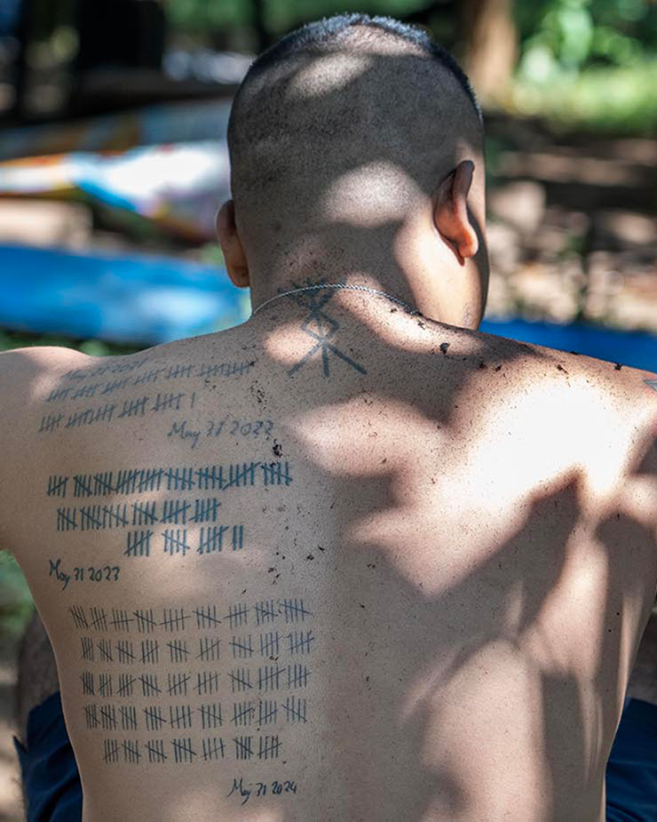 Man shows his back tattoos