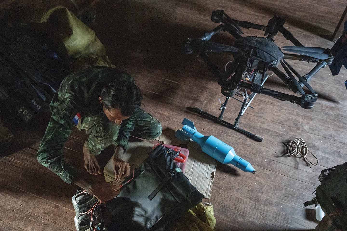 Drone pilot works on a drone on the floor