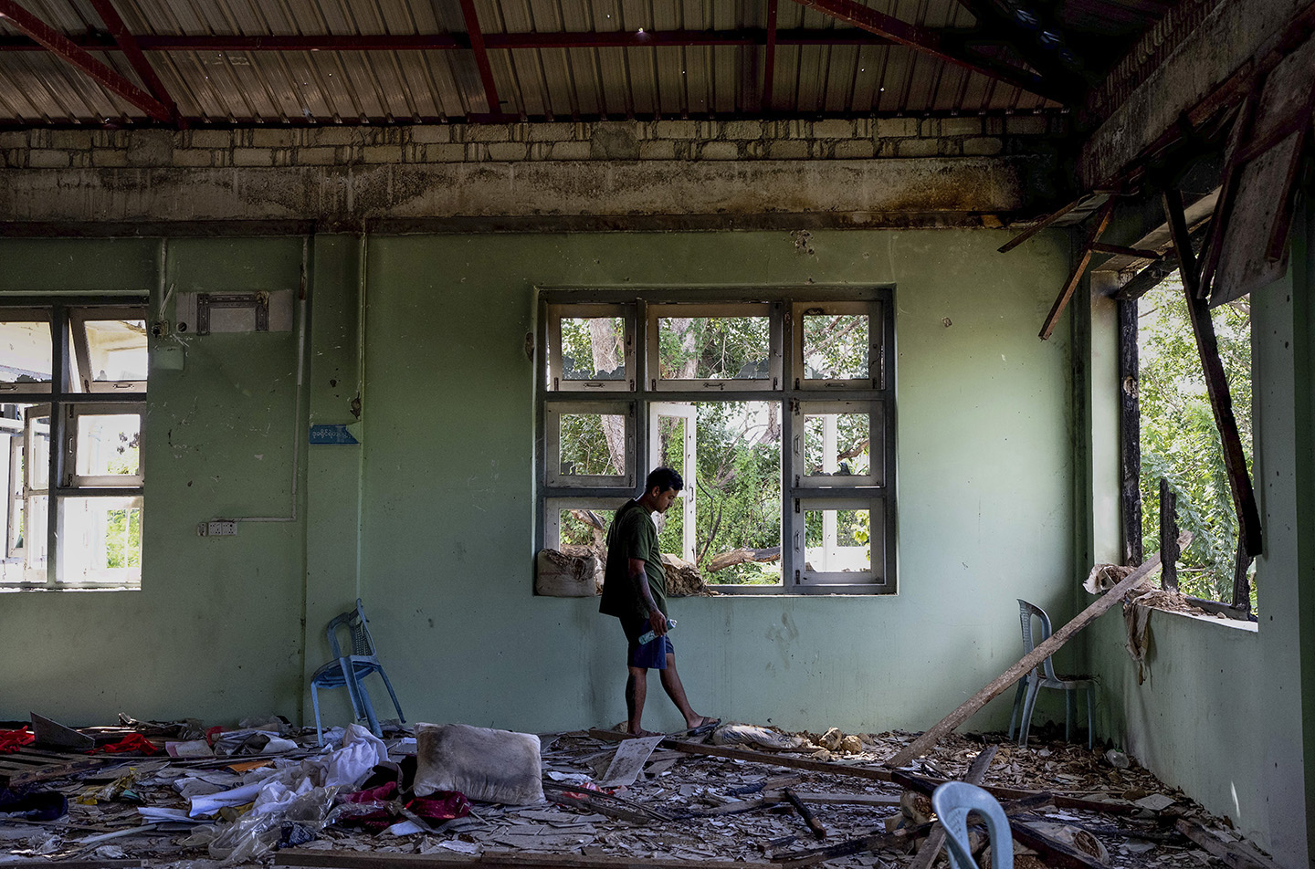 Man walks thorugh rubble in an abandoned building