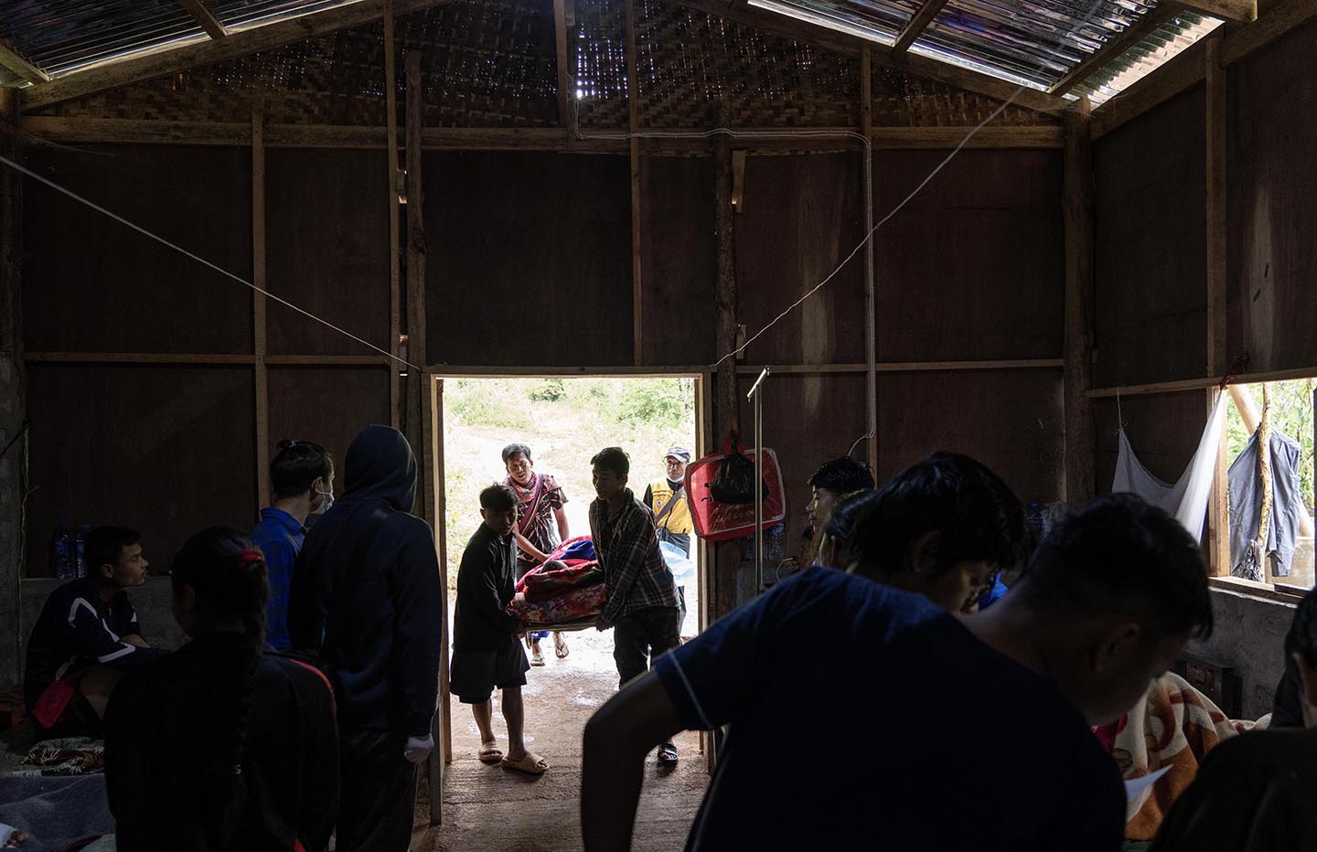 Men carry person through doorway of hospital