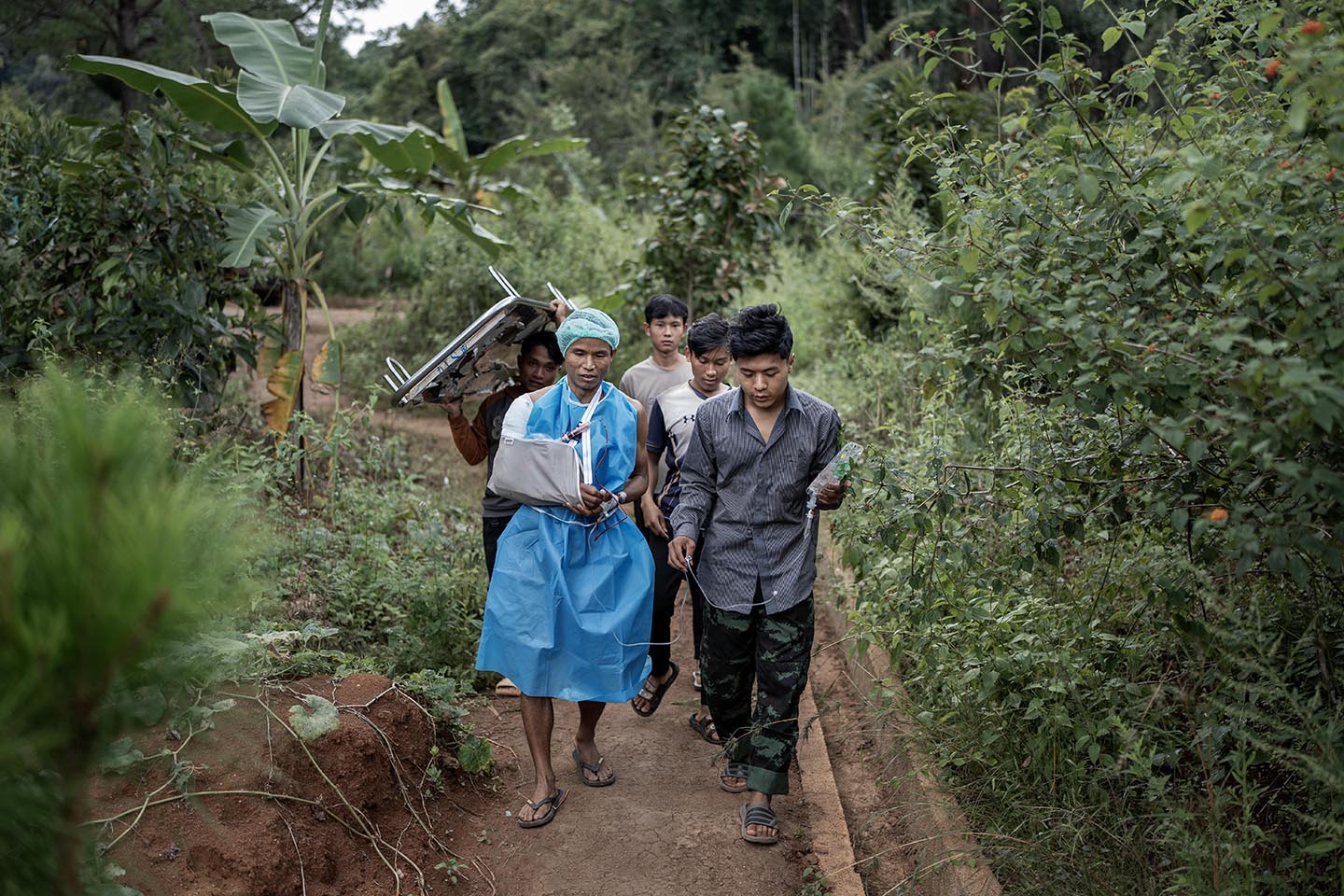 People walk down dirt path through greenery