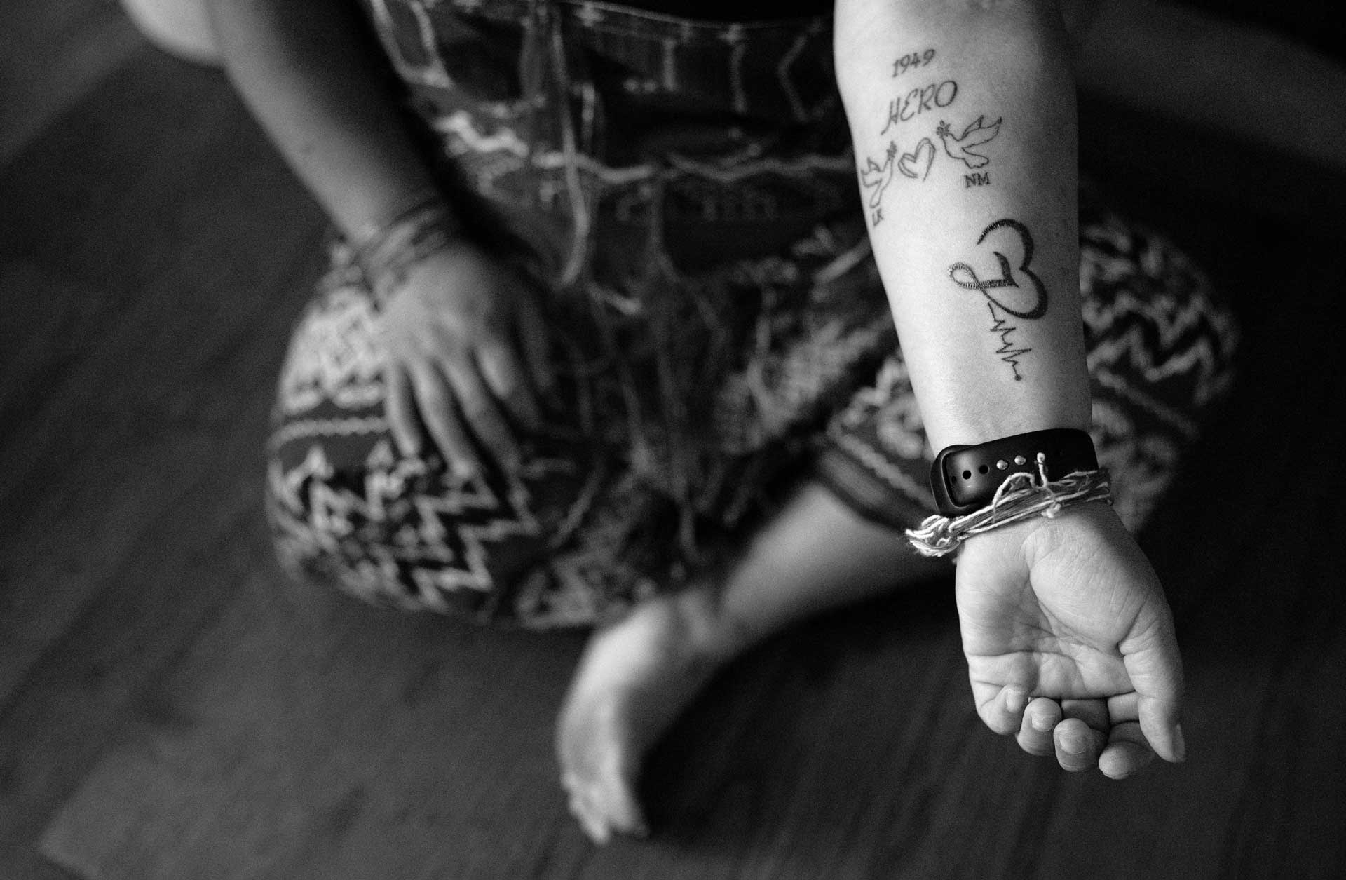 Soe Ka Byar, Nyah Mway’s aunt, shows her tattoo in Utica, New York, Aug. 18, 2024. NM stands for Nyah Mway and LX for her niece, Lah Kau Moon, who was shot and killed by the Myanmar military during a protest in 2021.