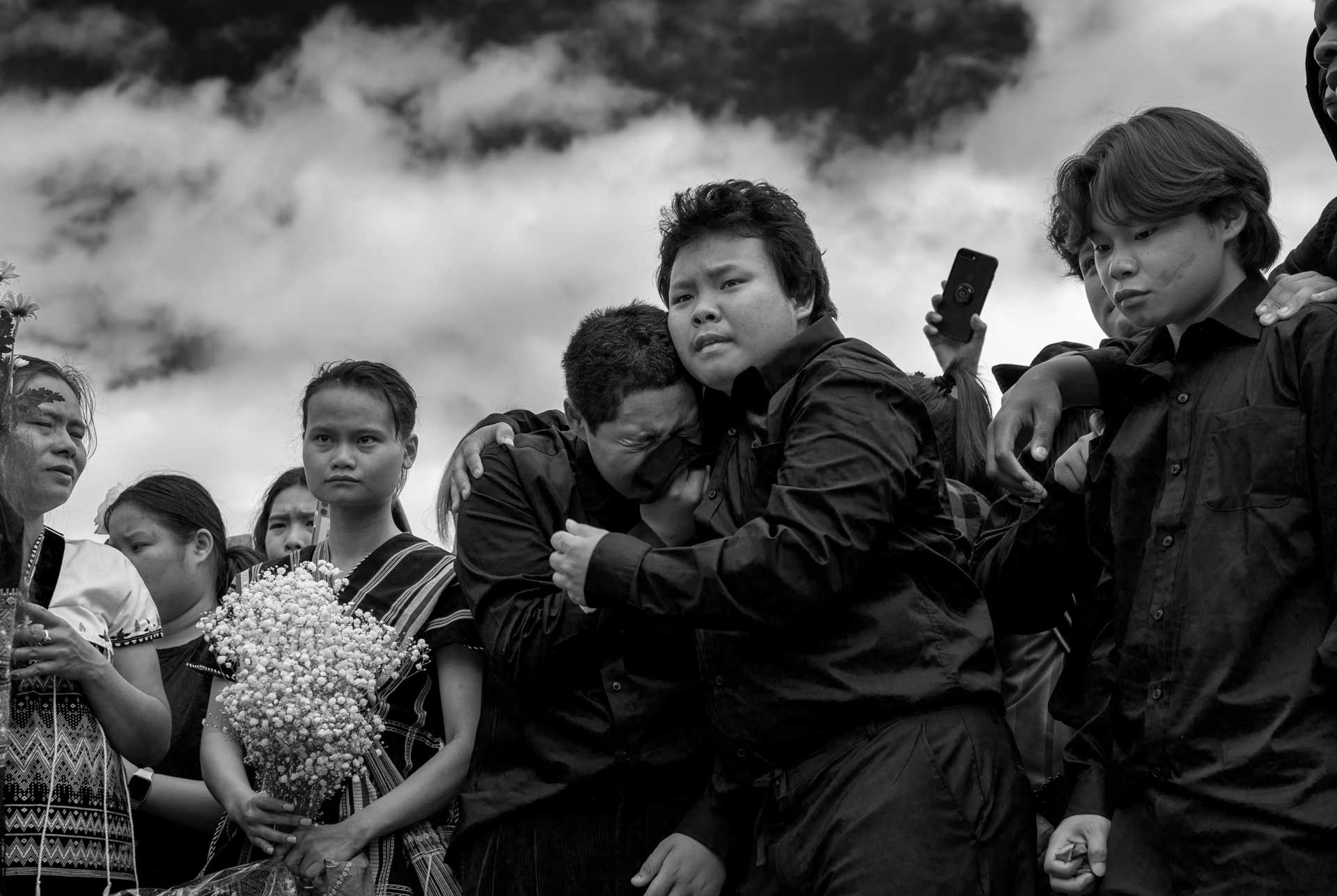 Thoung Oo, center, Nyah Mway’s eldest brother, comforts his weeping cousin Met Ka Pur Soe as his younger brother Maung Myint watches on during Nyah Mway’s the burial of Nyah Mway in Utica, New York, July 6, 2024.