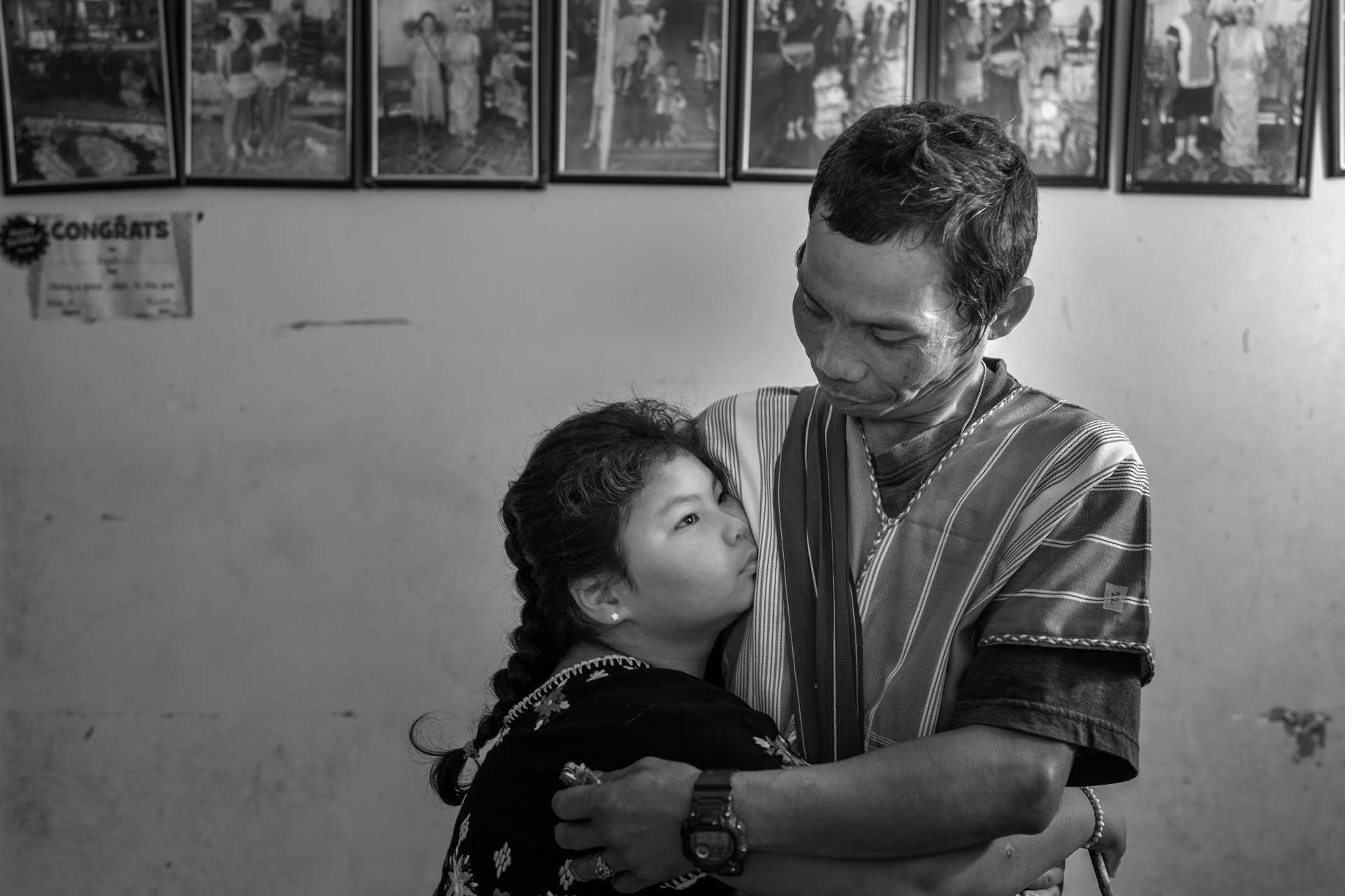 Nyah Mway’s younger sister Paw War hugs her father Ka Lee Wan at their home in Utica, New York, Aug. 17, 2024.